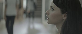 Movie still from “Breathe In” (2013), directed by Drake Doremus – A woman's face in a white room; Close Up shot, Over the shoulder angle