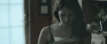 Movie still from “Breathe In” (2013), directed by Drake Doremus – A woman looking down at a book in her hands; Close Up shot, Over the shoulder angle