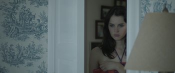 Movie still from “Breathe In” (2013), directed by Drake Doremus – A woman standing in front of a door looking at the camera; Close Up shot, Over the shoulder angle
