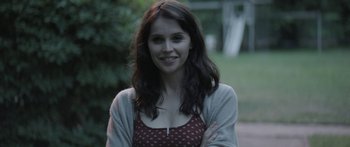 Movie still from “Breathe In” (2013), directed by Drake Doremus – A beautiful young lady smiling for the camera; Close Up shot, Over the shoulder angle