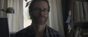 Movie still from “Breathe In” (2013), directed by Drake Doremus – A man with a beard wearing glasses and a plaid shirt; Close Up shot, Over the shoulder angle