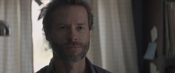 Movie still from “Breathe In” (2013), directed by Drake Doremus – A person with a beard looking at the camera; Close Up shot, Over the shoulder angle