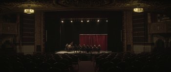 Movie still from “Breathe In” (2013), directed by Drake Doremus – A group of people sitting in front of a stage; Extreme Wide shot, High angle