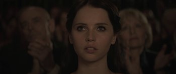 Movie still from “Breathe In” (2013), directed by Drake Doremus – A woman's face in a crowd of onlookers; Close Up shot, Over the shoulder angle