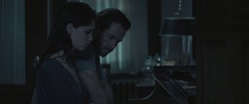 Movie still from “Breathe In” (2013), directed by Drake Doremus – A man and a woman are looking at something on a desk; Medium shot, Over the shoulder angle