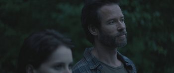 Movie still from “Breathe In” (2013), directed by Drake Doremus – A man and a woman are standing in the woods; Close Up shot, Over the shoulder angle