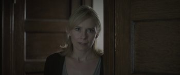 Movie still from “Breathe In” (2013), directed by Drake Doremus – A woman standing next to a wooden door; Close Up shot, Over the shoulder angle