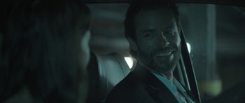 Movie still from “Breathe In” (2013), directed by Drake Doremus – A man sitting in the back seat of a car; Close Up shot, Over the shoulder angle