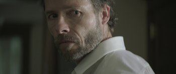 Movie still from “Breathe In” (2013), directed by Drake Doremus – A person wearing a white shirt; Close Up shot, Low angle
