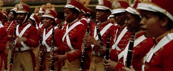Movie still from “Brewster McCloud” (1970), directed by Robert Altman – A group of men in red and gold marching band uniforms; Medium shot, High angle