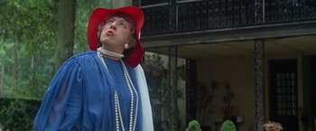 Movie still from “Brewster McCloud” (1970), directed by Robert Altman – An older woman wearing a red hat and a blue dress; Close Up shot, Low angle