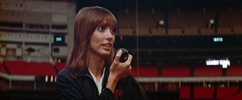 Movie still from “Brewster McCloud” (1970), directed by Robert Altman – A woman holding a cell phone in her hand; Close Up shot, Low angle