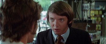 Movie still from “Brewster McCloud” (1970), directed by Robert Altman – A man in a suit and tie talking to another man in a suit and tie; Close Up shot, Over the shoulder angle