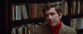 Movie still from “Brewster McCloud” (1970), directed by Robert Altman – A person wearing a jacket in front of a book shelf; Close Up shot, Over the shoulder angle