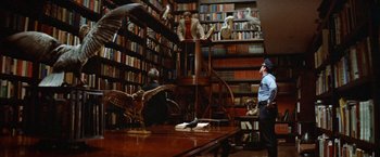 Movie still from “Brewster McCloud” (1970), directed by Robert Altman – A library filled with lots of books and people; Wide shot, High angle