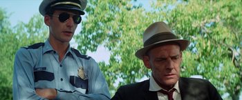Movie still from “Brewster McCloud” (1970), directed by Robert Altman – A man in a suit and a man in a hat; Close Up shot, Low angle
