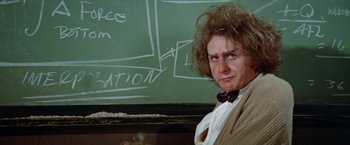 Movie still from “Brewster McCloud” (1970), directed by Robert Altman – A man in a suit standing in front of a chalkboard; Close Up shot, Over the shoulder angle
