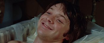 Movie still from “Brewster McCloud” (1970), directed by Robert Altman – A person smiling for the camera; Close Up shot, Low angle