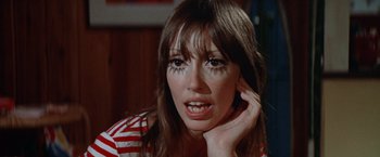 Movie still from “Brewster McCloud” (1970), directed by Robert Altman – A person wearing a striped shirt and holding her hand up to her face; Close Up shot, Low angle