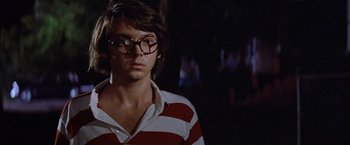 Movie still from “Brewster McCloud” (1970), directed by Robert Altman – A young man wearing glasses and a striped shirt; Close Up shot, Low angle
