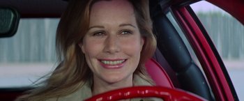 Movie still from “Brewster McCloud” (1970), directed by Robert Altman – A person in a car smiling for the camera; Close Up shot, Low angle