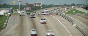 Movie still from “Brewster McCloud” (1970), directed by Robert Altman – Cars driving down a highway on a sunny day; Extreme Wide shot, High angle