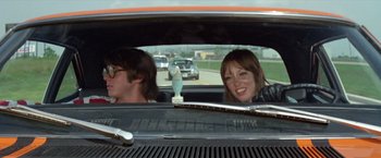 Movie still from “Brewster McCloud” (1970), directed by Robert Altman – A man and a woman sitting in the back of a car; Medium shot, Low angle