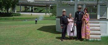 Movie still from “Brewster McCloud” (1970), directed by Robert Altman – A man and a woman dressed as a military man and a woman dressed as an old lady; Wide shot, Low angle