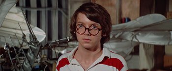 Movie still from “Brewster McCloud” (1970), directed by Robert Altman – A young man wearing glasses and a red and white striped shirt; Close Up shot, Low angle