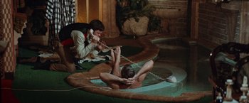 Movie still from “Brewster McCloud” (1970), directed by Robert Altman – A man is sitting in a pool talking on the phone; Wide shot, High angle