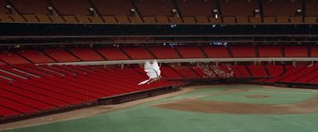 Movie still from “Brewster McCloud” (1970), directed by Robert Altman – A bird flying over a baseball field in an empty stadium; Extreme Wide shot, High angle