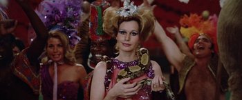 Movie still from “Brewster McCloud” (1970), directed by Robert Altman – A woman holding a snake in her hand; Close Up shot, Over the shoulder angle