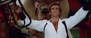 Movie still from “Brewster McCloud” (1970), directed by Robert Altman – A man standing next to a stuffed animal dog; Close Up shot, Low angle