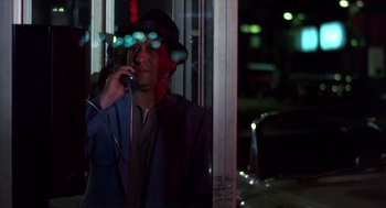 Movie still from “Brewster's Millions” (1985), directed by Walter Hill – A man talking on a phone while wearing a hat; Medium shot, Low angle