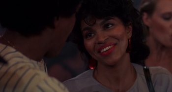 Movie still from “Brewster's Millions” (1985), directed by Walter Hill – A person smiling at the camera; Close Up shot, Over the shoulder angle