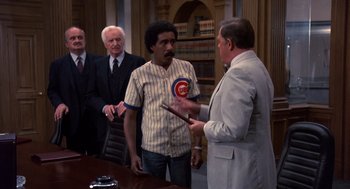 Movie still from “Brewster's Millions” (1985), directed by Walter Hill – Two men in a room with a judge; Medium shot, Over the shoulder angle