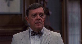Movie still from “Brewster's Millions” (1985), directed by Walter Hill – An older man in a suit and bow tie; Close Up shot, Over the shoulder angle
