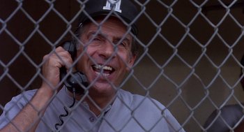 Movie still from “Brewster's Millions” (1985), directed by Walter Hill – A man in a baseball hat is talking on a phone; Close Up shot, Low angle
