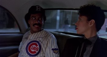 Movie still from “Brewster's Millions” (1985), directed by Walter Hill – A man and a woman sitting in the back of a car; Medium shot, Over the shoulder angle