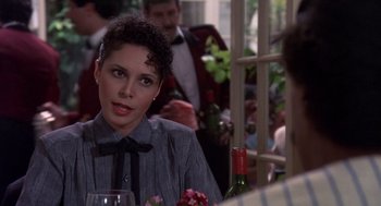 Movie still from “Brewster's Millions” (1985), directed by Walter Hill – A woman sitting at a table with a glass of wine; Close Up shot, Over the shoulder angle