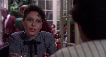 Movie still from “Brewster's Millions” (1985), directed by Walter Hill – A woman sitting at a table with a glass of red wine; Close Up shot, Over the shoulder angle