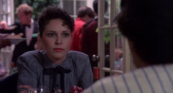Movie still from “Brewster's Millions” (1985), directed by Walter Hill – A woman sitting at a table with a glass of wine; Close Up shot, Over the shoulder angle