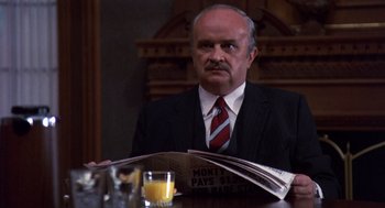 Movie still from “Brewster's Millions” (1985), directed by Walter Hill – A man sitting at a table with a glass of orange juice; Medium shot, Low angle