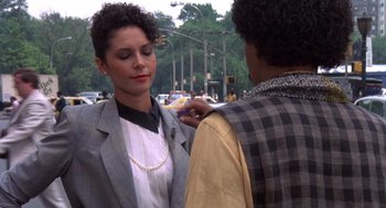 Movie still from “Brewster's Millions” (1985), directed by Walter Hill – A woman in a gray jacket is getting her hair brushed by another woman; Close Up shot, Over the shoulder angle