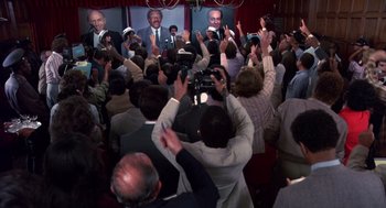 Movie still from “Brewster's Millions” (1985), directed by Walter Hill – A group of people standing in front of a crowd; Wide shot, High angle