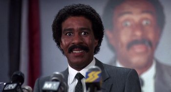 Movie still from “Brewster's Millions” (1985), directed by Walter Hill – A person wearing a suit and tie; Close Up shot, Low angle