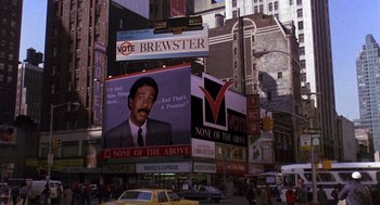 Movie still from “Brewster's Millions” (1985), directed by Walter Hill – A large billboard in the middle of a busy city street; Extreme Wide shot, High angle