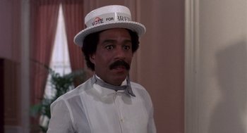 Movie still from “Brewster's Millions” (1985), directed by Walter Hill – A man wearing a hat that says " vote for barack " on it; Medium shot, High angle