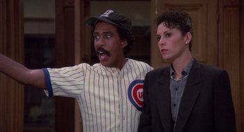 Movie still from “Brewster's Millions” (1985), directed by Walter Hill – A man and a woman are standing next to each other; Medium shot, Over the shoulder angle