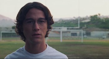 Movie still from “Brick” (2005), directed by Rian Johnson – A young man with glasses is looking at the camera; Close Up shot, Over the shoulder angle
